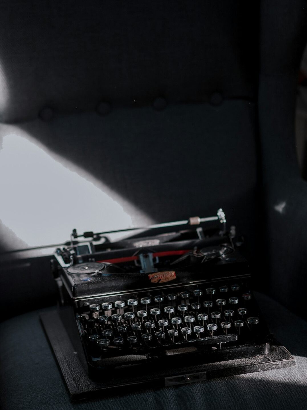 Vintage typewriter with a blank page under dramatic side light